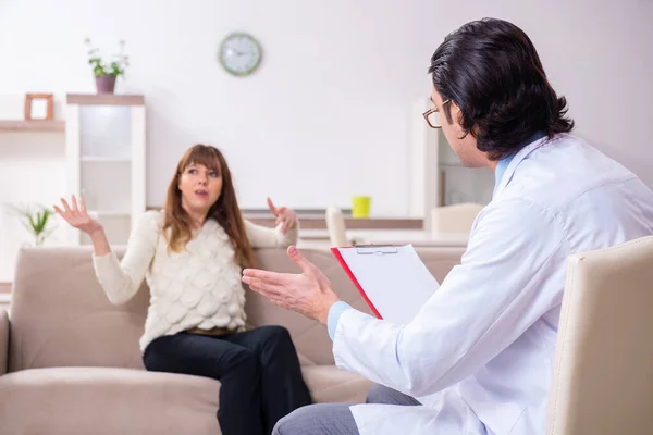 Paciente joven discutiendo con psicólogo masculino personal — Foto de Stock