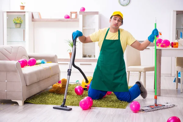 Jovem empreiteiro do sexo masculino fazendo trabalhos domésticos após a festa — Fotografia de Stock