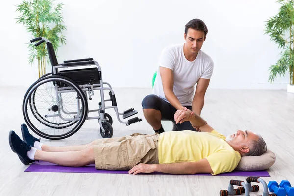 Old injured man doing exercises indoors