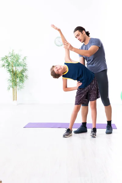 Jovem pai e seu filho fazendo exercícios — Fotografia de Stock