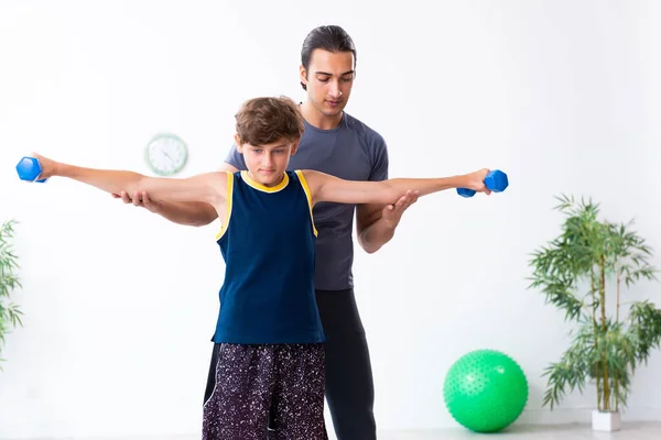 Jovem pai e seu filho fazendo exercícios — Fotografia de Stock