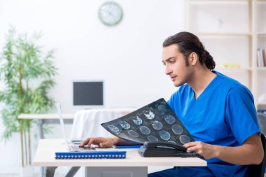 Klinikte çalışan genç erkek doktor.