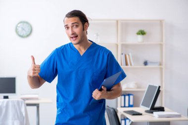 Klinikte çalışan genç erkek doktor.