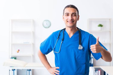 Klinikte çalışan genç erkek doktor.