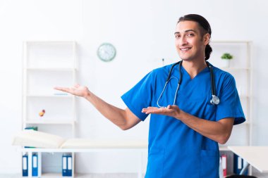 Klinikte çalışan genç erkek doktor.