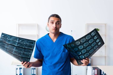 Klinikte çalışan genç erkek doktor.