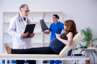 İki doktor genç kadını muayene ediyor.