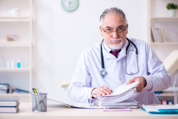 Old male doctor working in the clinic