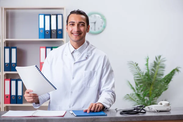 Young male doctor at the reception in the hospital — Stock Photo, Image