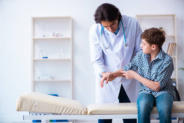 Hand injured boy visiting young male doctor