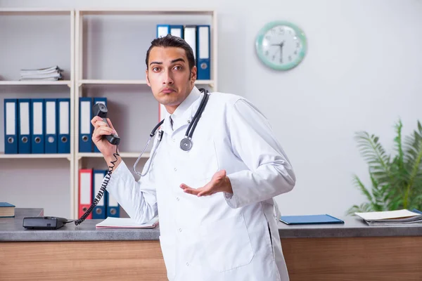 Ung manlig läkare i receptionen på sjukhuset — Stockfoto