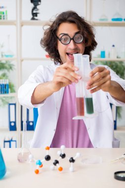 Laboratuvarda çalışan komik erkek kimyager.