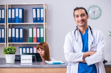 Hastanedeki resepsiyonda çalışan iki doktor.