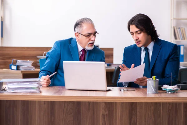 Empregados jovens e velhos trabalhando juntos no escritório — Fotografia de Stock