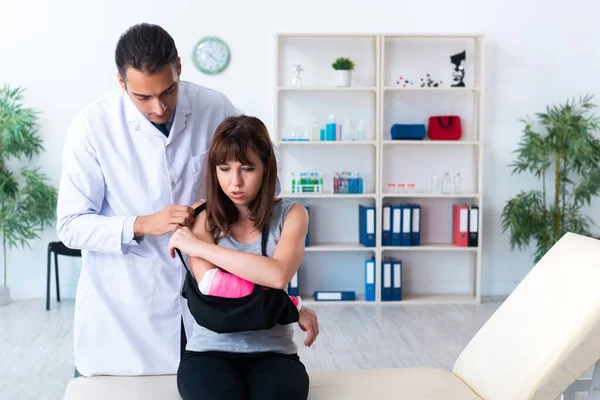 Jovem mulher visitando médico traumatologista masculino — Fotografia de Stock