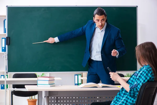 Jonge knappe leraar en vrouwelijke student in de klas — Stockfoto