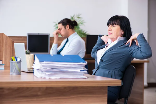 Twee medewerkers doen sport oefeningen in het kantoor — Stockfoto