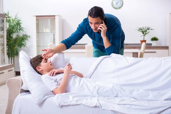 Padre joven que cuida de su hijo enfermo — Foto de Stock