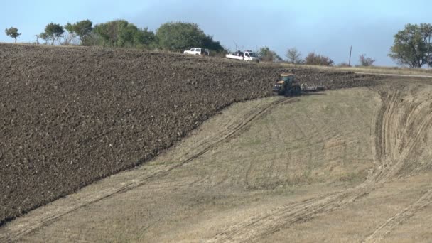 Itálie, Toskánsko - 20. září 2017: Traktor orá zemědělská pole na úbočí kopce. Příprava k setí plodin