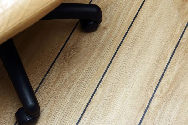 オフィスチェアに黒い縫い目のある寄木細工の床に — ストック写真