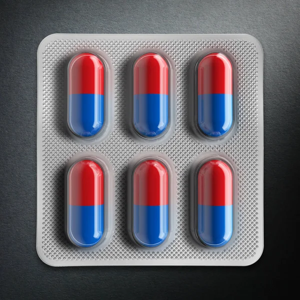 Red and blue pills in a blister on gray background