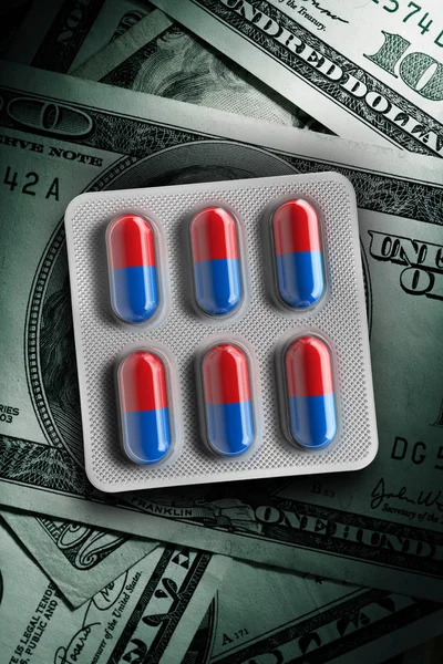 Red and blue pills in a blister on dollar bill background