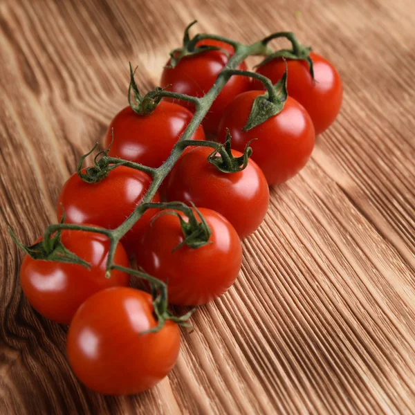 Tomates Cereja Maduros Vermelhos Galho Sobre Fundo Madeira — Fotografia de Stock Grátis