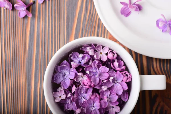 Foto Cerca Taza Blanca Llena Hermosas Flores Púrpuras Mesa Madera — Foto de Stock