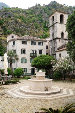 Dağlarda beyaz eski binalar olan çeşme