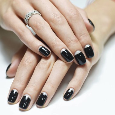 Beyaz arka planda izole edilmiş ay siyahı manikürlü kadın elleri.