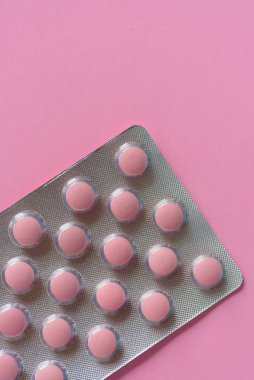 Pembe arka planda, fotokopi aletiyle su toplayan pembe ilaçlar.