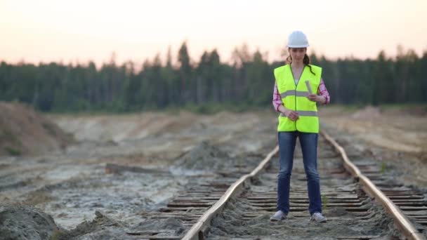 Una trabajadora menea su mano con luz de señal en el ferrocarril — Vídeo de stock