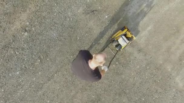 Man crushing gravel by special machine on road — Stock Video