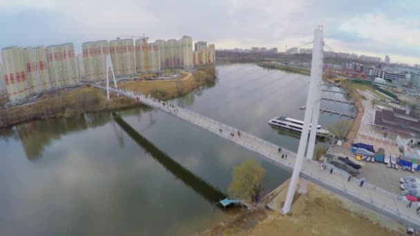 Puente de cable con peatones a pie sobre el río — Vídeo de stock