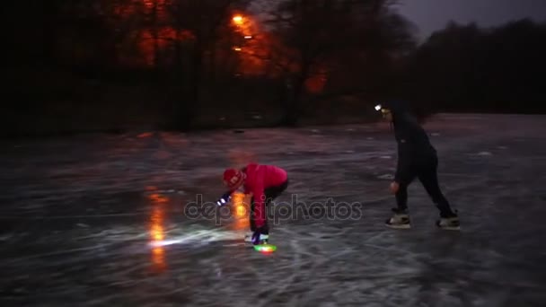 Man and girl skate on natural ice rink — Stock Video