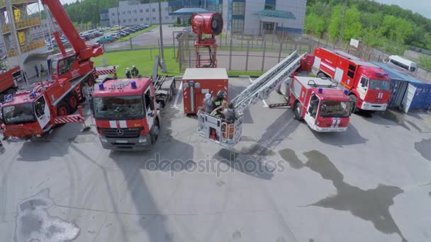 Reporteros con bombero elevan en cabina en escalera — Vídeo de stock