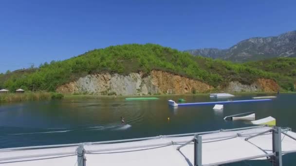 Mann fährt auf Surfbrett am Teich — Stockvideo