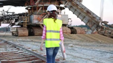 Kadın işçi kariyer Stacker yakınındaki demiryolu üzerinde yürüyor