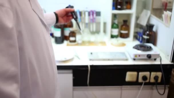 Руки человека, работающего в химической лаборатории — стоковое видео