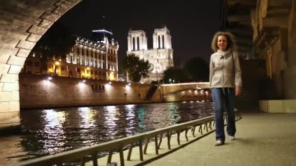 Vrouw wandelingen langs de dijk van de Seine in de avond — Stockvideo