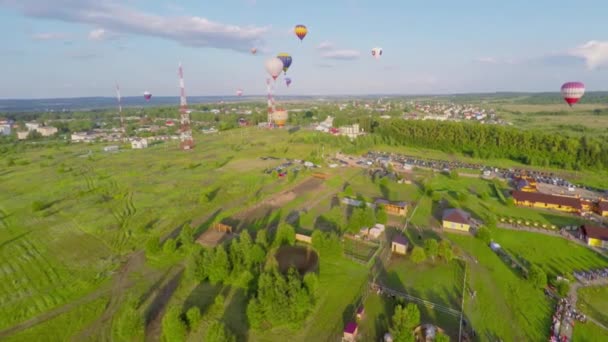 Пейзаж с воздушными шарами, летящими над полями — стоковое видео