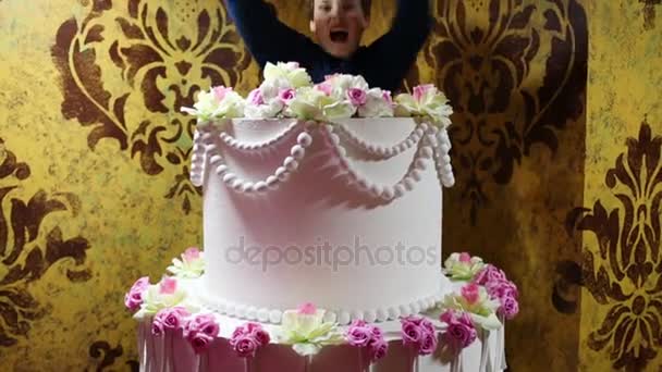 Chico salta fuera de enorme pastel — Vídeo de stock