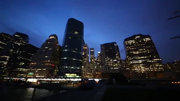 Hoge gebouwen in de buurt van water in de nacht in New York — Stockvideo