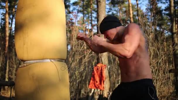Muž udeří improvizované boxovací pytel — Stock video