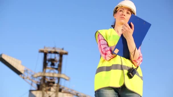 Eine Arbeiterin mit Radio schreibt auf das Papier — Stockvideo