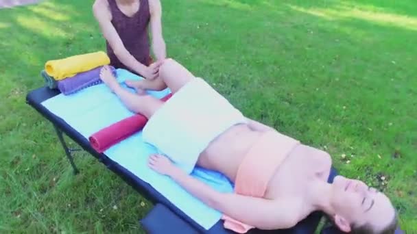 Homem faz massagem para mulher que coloca na mesa — Vídeo de Stock