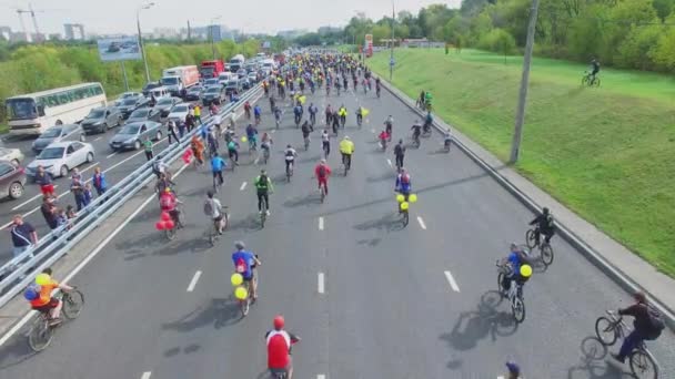 Cyclists ride by highway near traffic jam — Stock Video