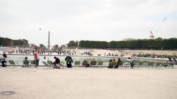 Mensen krijgen de rest rond Bassin octogonale met fontein — Stockvideo