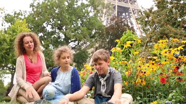 Moeder, jongen en meisje zitten op gras — Stockvideo