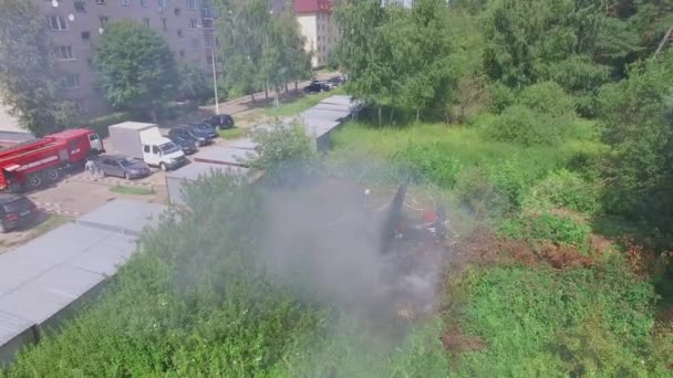 Bombeiros extinguem incêndio perto de garagens e estacionamento — Vídeo de Stock